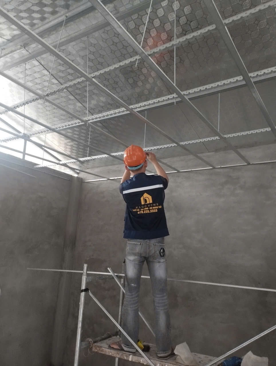 Công nhân lắp đặt hệ thống trần nhà trên giàn giáo