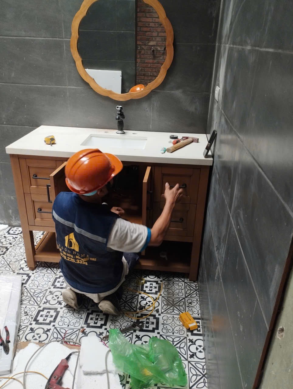 Công nhân cải tạo phòng tắm với trang phục bảo hộ