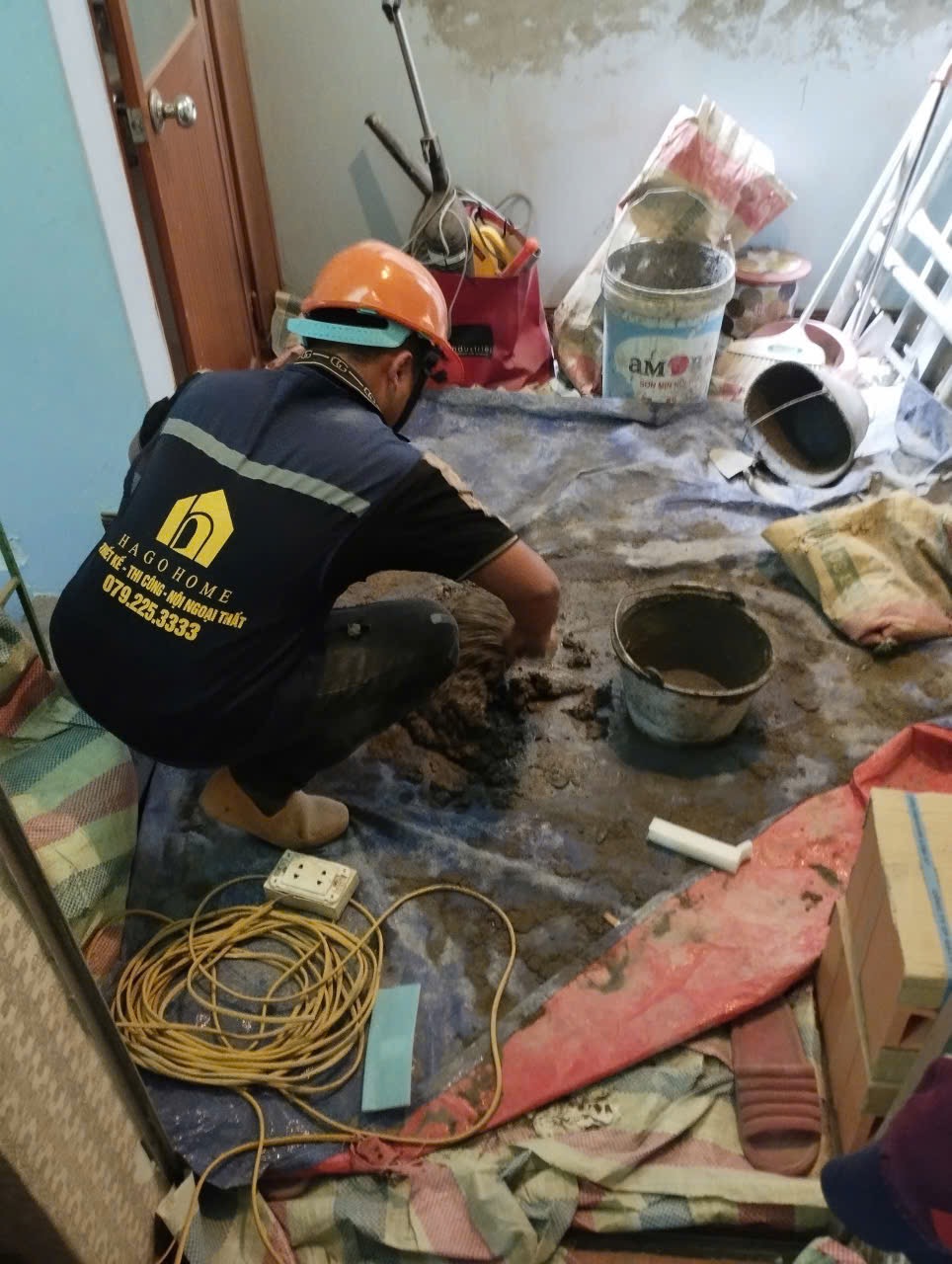 Công nhân cải tạo nhà với dụng cụ và đồ bảo hộ